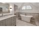 A bright bathroom featuring a soaking tub, modern vanity, and decorative fixtures at 117 Wrenwood Ln, Charlotte, NC 28211