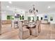 Open-concept dining area with a large table, modern lighting, and views of the kitchen and living space at 117 Wrenwood Ln, Charlotte, NC 28211