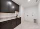 Laundry area features stylish dark cabinets, marble counters, and modern fixtures at 117 Wrenwood Ln, Charlotte, NC 28211