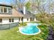 Backyard view featuring the custom pool surrounded by turf and mature trees at 117 Wrenwood Ln, Charlotte, NC 28211