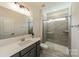 Modern bathroom featuring a glass enclosed shower, updated lighting, and gray vanity at 12526 Dunloe Wood Dr, Huntersville, NC 28078