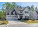 Charming two-story home with three-car garage, dark shutters and manicured landscaping at 12526 Dunloe Wood Dr, Huntersville, NC 28078