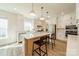 Bright kitchen with white cabinetry, stainless steel appliances, large island with seating, and pendant lighting at 12526 Dunloe Wood Dr, Huntersville, NC 28078