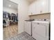 The laundry room boasts storage cabinets above the appliances and a peek into the walk-in closet space at 12526 Dunloe Wood Dr, Huntersville, NC 28078
