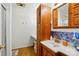 A cozy bathroom featuring a sink and vanity with blue patterned tiling, as well as a wooden cabinet for storage at 140 Oak Ave, Mount Holly, NC 28120