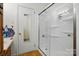 A cozy bathroom featuring a white tiled shower with glass doors, and a door with a mirror on it at 140 Oak Ave, Mount Holly, NC 28120