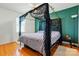 This bedroom features hardwood floors, a ceiling fan, and a unique four-poster canopy bed with lace and vine accents at 140 Oak Ave, Mount Holly, NC 28120