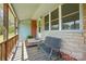 Inviting covered front porch with stone accents, a bench, and a view of the surrounding greenery at 140 Oak Ave, Mount Holly, NC 28120