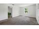 Neutral room with plush carpeting, featuring natural light from the window and easy access to adjacent spaces at 140 Oak Ave, Mount Holly, NC 28120