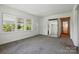 Spacious living room features plush carpet, large windows, and a stylish mirror at 140 Oak Ave, Mount Holly, NC 28120