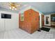 A bright sun room featuring brick walls, a ceiling fan, and a television at 140 Oak Ave, Mount Holly, NC 28120
