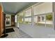 A bright sun room with tiled floors and plenty of windows looking out onto the backyard at 140 Oak Ave, Mount Holly, NC 28120