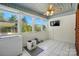 A bright sun room featuring tiled floors, a ceiling fan, a television, and plenty of windows at 140 Oak Ave, Mount Holly, NC 28120