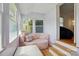 Bright sunroom featuring hardwood floors, natural light and unique seating with pink sofa and pillows at 140 Oak Ave, Mount Holly, NC 28120