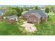 Lush backyard with brick home, detached structure, patio, fire pit, and manicured lawn at 15118 Marshall Valley Ct, Mint Hill, NC 28227