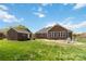 Spacious backyard featuring brick house and stone patio with chairs at 15118 Marshall Valley Ct, Mint Hill, NC 28227