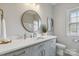 Bathroom with gray vanity, white countertop, round mirror, and modern fixtures at 15118 Marshall Valley Ct, Mint Hill, NC 28227