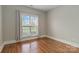 Bright bedroom featuring a large window, neutral walls, and wood floors at 15118 Marshall Valley Ct, Mint Hill, NC 28227