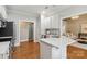 Bright kitchen features white cabinets, quartz countertops, stainless steel appliances, and wood floors at 15118 Marshall Valley Ct, Mint Hill, NC 28227