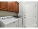 Well-organized laundry room features modern washer and dryer units and upper cabinets for storage at 15118 Marshall Valley Ct, Mint Hill, NC 28227