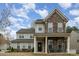 Charming two-story home featuring stone accents, a welcoming front porch, and manicured landscaping at 15324 Colonial Park Dr, Huntersville, NC 28078
