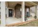 Inviting front porch with brick accents, seating, and a decorative front door at 15324 Colonial Park Dr, Huntersville, NC 28078