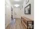 Bright hallway with hardwood floors, modern decor, and a view of the front door at 15324 Colonial Park Dr, Huntersville, NC 28078