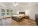 Bright main bedroom with tray ceiling, ceiling fan, and two windows at 15324 Colonial Park Dr, Huntersville, NC 28078
