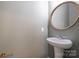 Stylish powder room with pedestal sink and oval mirror with wood trim at 15324 Colonial Park Dr, Huntersville, NC 28078
