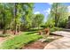 Large backyard with mature trees, flowering shrubs, outdoor fireplace and patio at 1536 Bear Mountain Rd, Charlotte, NC 28214