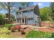 Charming backyard featuring a wooden deck, stone patio, and vibrant flowers, perfect for outdoor entertaining at 1536 Bear Mountain Rd, Charlotte, NC 28214
