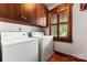 Laundry room features modern washer and dryer units, cabinetry, and natural light from the window at 1536 Bear Mountain Rd, Charlotte, NC 28214