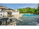 Inviting community pool surrounded by lounge chairs and tables under umbrellas, all surrounded by mature trees at 162 Limerick Rd # C, Mooresville, NC 28115