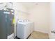 Bright laundry room featuring neutral paint, a hot water heater, and a washer and dryer at 162 Limerick Rd # C, Mooresville, NC 28115