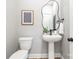 Modern half bath with a pedestal sink, unique mirror, and neutral wall color at 2003 Ashley Rd # B, Charlotte, NC 28208