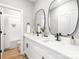 Stylish bathroom showcases double vanity, framed mirrors, and tub-shower combo with tile surround at 2003 Ashley Rd # B, Charlotte, NC 28208
