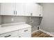 Functional laundry room features modern cabinetry, a counter top, and washer/dryer hookups at 2003 Ashley Rd # B, Charlotte, NC 28208