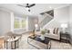 Cozy living room with neutral tones, a modern staircase, and ample natural light streaming through the windows at 2003 Ashley Rd # B, Charlotte, NC 28208