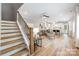 Open-concept living room with modern furnishings, a cozy dining area, and sleek staircase at 2003 Ashley Rd # B, Charlotte, NC 28208