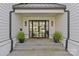 Home's stylish double-door entry featuring glass panels, stone steps, and decorative plants at 2637 Normandy Rd, Charlotte, NC 28209