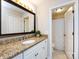 Bathroom featuring a granite countertop, white cabinetry, and a framed mirror, with an adjacent toilet room at 2719 Selwyn Ave # 3, Charlotte, NC 28209