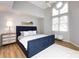 Bright bedroom showcasing a large bed with a blue headboard, light-colored walls, and unique round window at 2719 Selwyn Ave # 3, Charlotte, NC 28209