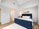Well-lit bedroom featuring a plush white rug, blue headboard bed, and wood-look floors at 2719 Selwyn Ave # 3, Charlotte, NC 28209