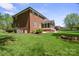 Large backyard with lawn, patio, fire pit, and brick exterior with screened porch at 2840 Wheatfield Ct, Lincolnton, NC 28092