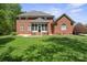 A spacious red brick two-story home showcasing a screened porch and well-maintained lawn at 2840 Wheatfield Ct, Lincolnton, NC 28092