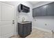 Clean laundry area features tiled floors, sink, cabinets and overhead racks at 2840 Wheatfield Ct, Lincolnton, NC 28092
