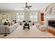 Bright living room with fireplace, ceiling fan, hardwood floors, and large windows with white shutters at 2840 Wheatfield Ct, Lincolnton, NC 28092