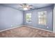 This bedroom offers neutral walls, plush carpeting and a ceiling fan at 3010 Berry Creek Rd, Charlotte, NC 28214