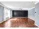 Open bonus room features wood-look floors, neutral paint, large window, and modern ceiling fan at 3010 Berry Creek Rd, Charlotte, NC 28214