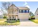 Traditional two-story home showcasing a columned porch, stone accents, two-car garage, and landscaped front yard at 3010 Berry Creek Rd, Charlotte, NC 28214